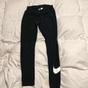 Nike mid rise black leggings with nike swoosh on the bottom left leg